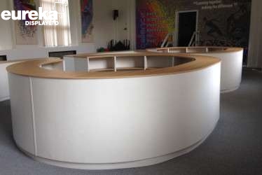 A slick curvy table which has been assembled by Eureka Manufacturing and looks like it is being used in a meeting